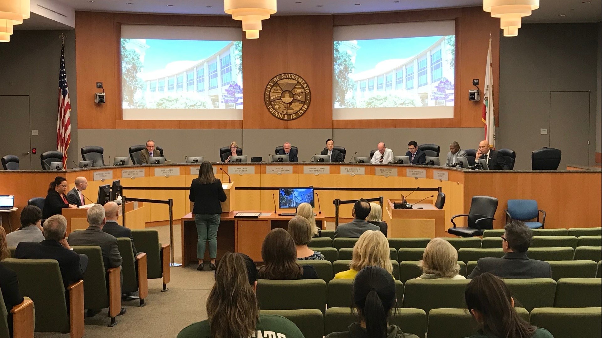 A resident speaks at the podium during public comment at a city council meeting.